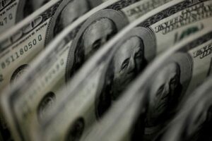 Dollar clings to gains as US rate outlook diverges from peers